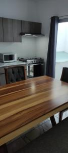 a kitchen with a wooden table and a stove at Kahjú Arandas Depa in Arandas
