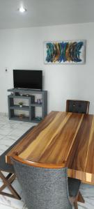 a wooden table in a living room with a television at Kahjú Arandas Depa in Arandas