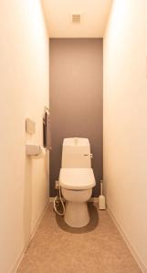 a bathroom with a white toilet in a room at Nagomi Apartment Hotel in Hatsukaichi