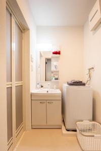 a bathroom with a sink and a mirror at Nagomi Apartment Hotel in Hatsukaichi