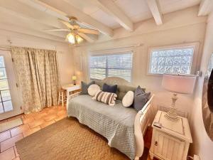 a living room with a couch and a ceiling fan at Baked Beach Bungalow in St. George Island +21 photos