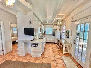 a kitchen with a white table and a tv on top at Baked Beach Bungalow in St. George Island