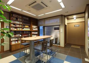 a library with a table and chairs in it at Toyooka Green Hotel Morris in Toyooka