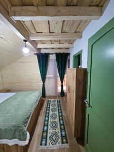 a bedroom with a bed and a green door at Casa din fagi in Munună