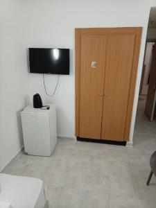 a room with a wooden door and a television at אלמוגי אוראל in Eilat +14 photos