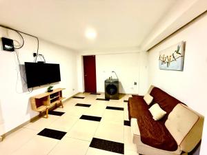 a living room with a couch and a flat screen tv at Comfort House in Lima