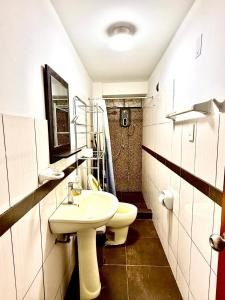 a bathroom with a white sink and a toilet at Comfort House in Lima +6 photos