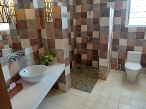 a bathroom with a sink and a toilet at Bayview Gardens Hotel in Labuan Bajo