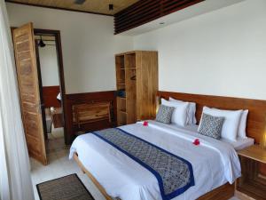 a bedroom with a large bed with white sheets at Bayview Gardens Hotel in Labuan Bajo +63 photos