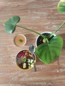 a bowl of food on a table with a plant at Trika Surfcamp Bali in Airsatang