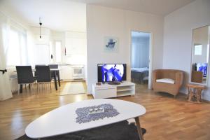 ein Wohnzimmer mit Fernseher und Tisch in der Unterkunft Northern Lights Apartment in Rovaniemi