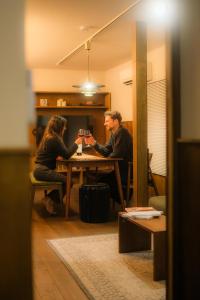 a man and woman sitting at a table holding hands at HOTEL RIN TOKYO - Private Townhouse - in Tokyo
