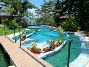 two swimming pools with plants in the water at Ecolodge Rancho del Lago in Santomé