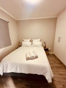 a bedroom with a white bed with towels on it at Table Mountain View Apartment II in Cape Town