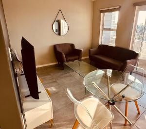 a living room with a glass table and a couch at Table Mountain View Apartment II in Cape Town