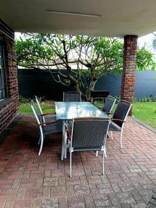 a table and chairs on a brick patio at Happy Jack - Margate in Margate