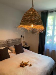 a stuffed teddy bear on a bed under a chandelier at charming guest house in Bolbec