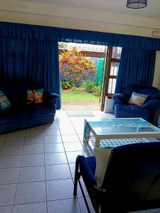 a living room with two couches and a glass table at Happy Jack - Margate in Margate