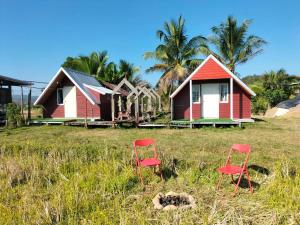 two red chairs in front of a row of houses at Ricefield Homestay มองนาภูคาน่านโฮมสเตย์ in Ban Thon (1)