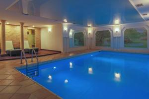 a large swimming pool with blue water in a building at Hotel-Restaurant Kunz in Pirmasens
