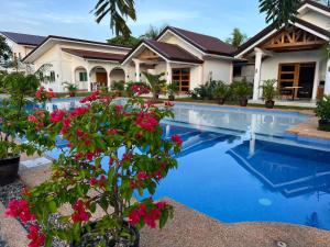 a villa with a swimming pool and flowers at Buenacosa Resort in Panglao Island