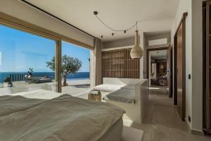 a bedroom with two beds and a view of the ocean at Villa Noema in Agiassos +42 photos