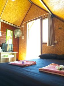 a bedroom with a large blue bed with a window at Ricefield Homestay มองนาภูคาน่านโฮมสเตย์ in Ban Thon (1)