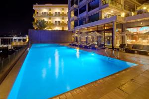a swimming pool lit up at night on a building at Two Seasons Coron Bayside Hotel in Coron
