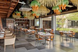 a dining room with tables and chairs and windows at Two Seasons Coron Bayside Hotel in Coron
