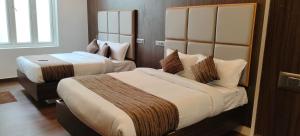a hotel room with two beds and a window at Le Grace Bye Pass in Madurai