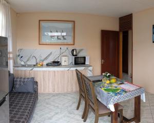 a kitchen with a table with chairs and a kitchen with a counter at Desirella Villa APARTMENT in Mahébourg