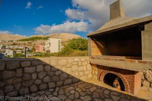an outdoor brick oven with a stone wall at Sladana direct at the beach in Metajna