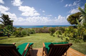 eine Terrasse mit Tisch und Stühlen und dem Meer in der Unterkunft Pointe des Châteaux in Saint-François