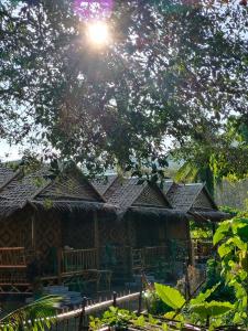 a building with roofs with the sun in the sky at Kohmook Money RUEAN PHAI in Trang