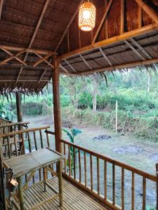 a porch with a picnic table and a chandelier at Kohmook Money RUEAN PHAI in Trang +6 photos
