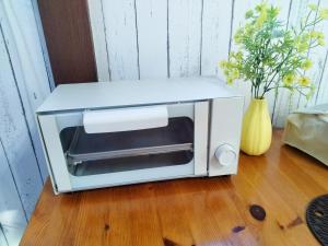 a microwave oven sitting on top of a wooden floor at さくらvilla in Tateyama