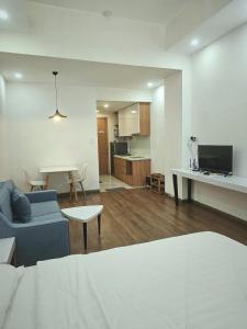 a living room with a blue couch and a kitchen at SAIGON GARDEN HILL Resort & Apartment in Ho Chi Minh City