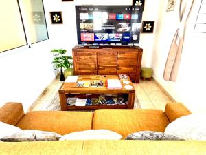 a living room with a couch and a flat screen tv at Gîte Délia Les Makes in Saint-Louis