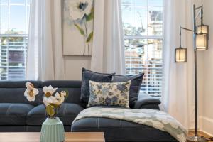 a living room with a blue couch and a vase of flowers at Stunning 4BR-5BR near French Quarter Homes by Hosteeva in New Orleans +37 photos