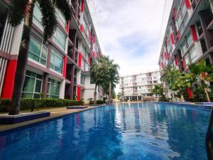 a swimming pool in the middle of two buildings at Pattaya Pool View Condo in Nong Prue