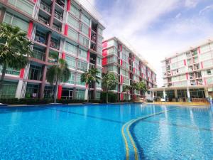 a large swimming pool in front of a building at Pattaya Pool View Condo in Nong Prue +26 photos