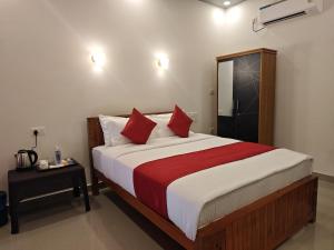 a bedroom with a large bed with red pillows at Lake Star Beach Resort in Kappil