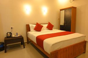 a bedroom with a large bed with red pillows at Lake Star Beach Resort in Kappil +6 photos