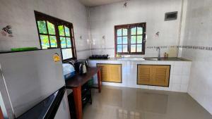 a kitchen with a sink and a refrigerator at Beach Path in Haad Chao Phao