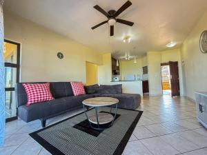a living room with a couch and a ceiling fan at 28 Breaker View 3-bedroom beach apartment in Durban