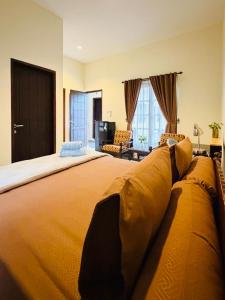 a large bedroom with a large bed with yellow sheets at Juni Residence in Pineleng