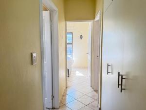 a hallway with a door leading to a room at 28 Breaker View 3-bedroom beach apartment in Durban +16 photos