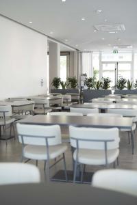 a dining room with white tables and white chairs at Hotel Seaview in Rimini