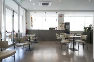 a dining room with tables and chairs and windows at Hotel Seaview in Rimini