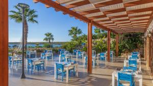 a restaurant with blue chairs and tables on a patio at Aquasis De Luxe Resort & SPA - Ultra All Inclusive in Didim